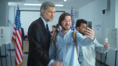 Çok ırklı insanlar oy kullandıktan sonra olgun başkan adaylarına geliyorlar. Amerikan vatandaşları oy kullanma merkezinde Amerikalı politikacılarla konuşuyor ve selfie çekiyorlar. Amerika Birleşik Devletleri Ulusal Seçim Günü.