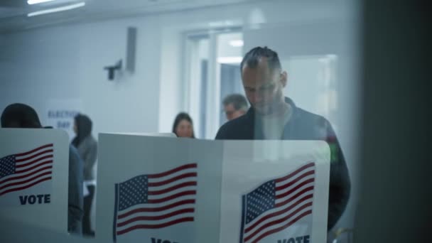 男性コーカサス市民は 投票所のブースで投票に来る アメリカ合衆国の国民選挙の日 アメリカ合衆国大統領候補の政治的競争 市民の義務と愛国心の概念 — ストック動画