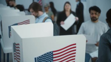 Çok ırklı Amerikan vatandaşları oy kullanma merkezindeki kabinlerde oy kullanırlar. Birleşik Devletler 'de Ulusal Seçim Günü. ABD başkan adaylarının siyasi ırkları. Vatandaşlık görevi ve vatanseverlik. Dolly vurdu..