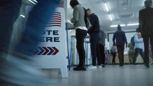 床にサインを投票してください 多様なアメリカ市民が投票所のブースで投票します アメリカ合衆国の国民選挙の日 アメリカ合衆国大統領候補の政治的競争 市民としての義務 — ストック動画