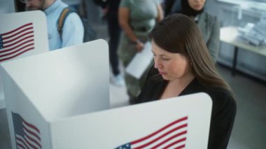 Modern oy kullanma merkezindeki kabinde kadın Amerikan vatandaşı oy kullanıyor. Birleşik Devletler 'de Ulusal Seçim Günü. ABD başkan adaylarının siyasi ırkları. Vatandaşlık görevi ve vatanseverlik kavramı.
