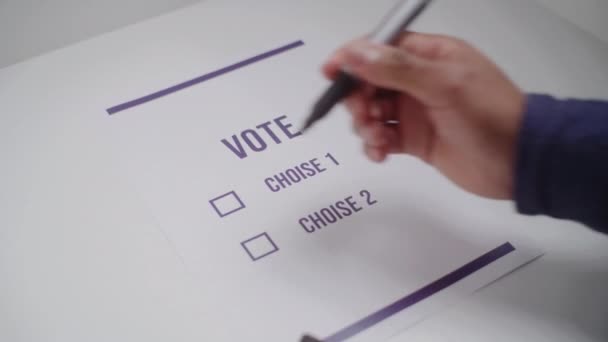 接近匿名的非裔美国人作出选择 在投票站投票给总统候选人或政党 男性选民在选举期间填写选票 公民义务概念 — 图库视频影像