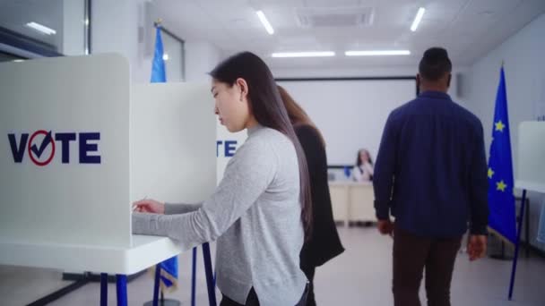 亚洲女人在投票站填写选票的多莉照片 在欧盟选举期间 不同的欧洲人在投票站投票 欧洲联盟的选举日 公民义务和民主概念 — 图库视频影像