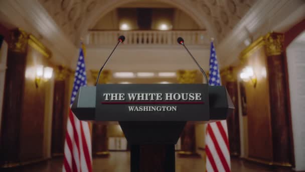 アメリカ合衆国大統領またはホワイトハウスの政府代表のための演説裁判所 ポディウムの議論はマイクで立っています 背景にあるアメリカの国旗 プレスカンファレンスコンセプト — ストック動画