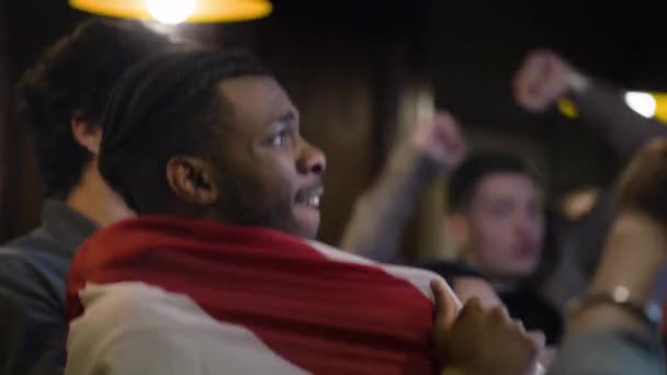 Zamknij Afroamerykańskiego Fana Świętującego Przyjaciółmi Gdy Drużyna Piłki Nożnej Strzela — Wideo stockowe