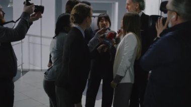 Meşgul kadın bakan basın sorularını yanıtlıyor ve hükümet binasının koridorunda basına röportaj veriyor. Etrafı televizyon gazetecileriyle çevrili kendinden emin bir politikacı. Sıcak düğme sorunları.