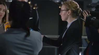 Çeşitli gazeteciler siyasetçi veya hükümet temsilcisiyle konuşuyor, medya veya televizyon haberleri için röportaj yapıyor. Kameramanlar televizyon için canlı yayın yapıyor. Basın toplantısı sırasında muhabirler.