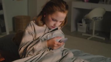 Güzel genç bir kız odasında peluş oyuncaklarla battaniyenin altına uzanıp dinleniyor. Tatlı liseli kız akşamları telefon kullanarak sosyal ağları tarıyor. Rahat bir ev, rahat bir iç mekan..
