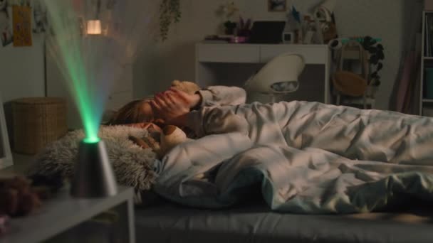 Молода Дівчина Лежить Ліжку Під Ковдрою Плюшевими Іграшками Відпочиває Кімнаті — стокове відео