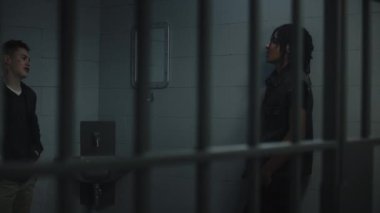 Hapishane hücresinde bir grup genç mahkum birbiriyle konuşuyor. Çok ırklı gençler gözaltı merkezinde hapis yatıyorlar. Hücredeki genç mahkumlar. Adalet sistemi. Metal çubuklardan bak.