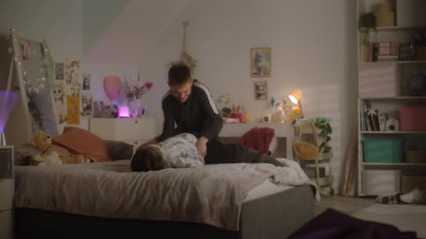 Chica Joven Entra Dormitorio Salta Cama Chico Trata Sacar Tableta — Vídeo de stock
