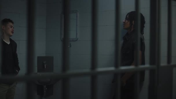 一群青少年囚犯在监牢里互相交谈 多族裔青少年在拘留中心服刑 关在牢房里的年轻囚犯 司法系统 透过金属棒观看 — 图库视频影像