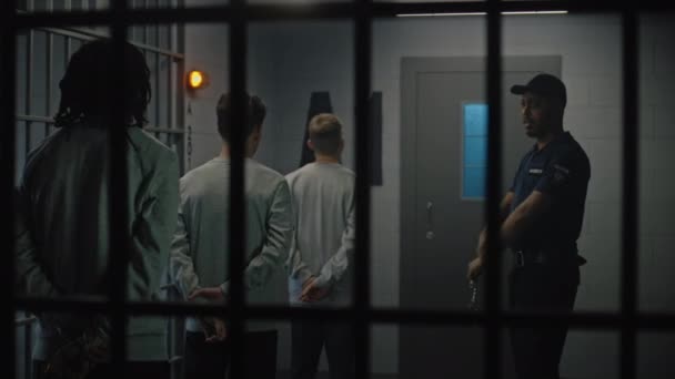 一群囚犯站在监牢附近 监狱长与他们交谈 多元文化青少年在拘留中心服刑 监狱里的年轻囚犯 司法系统 透过金属棒观看 — 图库视频影像