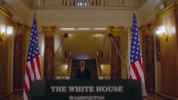 美国总统上任后 开始在白宫发表感情用事的政治演说 年长的国会议员在新闻发布会上代表媒体和电视发表讲话 背景中的美国国旗 — 图库视频影像