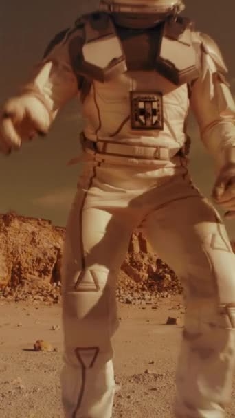身穿宇航服的人打开相机 指着干旱的地形 同时从火星表面记录带有蓝色界面的视频信息 垂直射击 — 图库视频影像