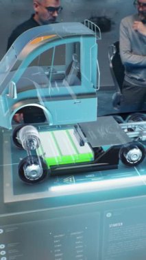 İki erkek otomotiv mühendisi, geleceğin sanal gerçeklik holografik modelini kullanarak elektrik motorlu yeni bir çevre dostu kamyon yarattılar. Modern aracın 3 boyutlu bilgisayar grafikleri gelişiyor. Dikey çekim