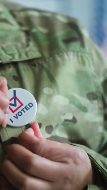 近距离的匿名军人佩带徽章与美国国旗的标志和题词我投了票 选举期间 美国陆军在投票站的代表 美国全国选举日 — 图库视频影像