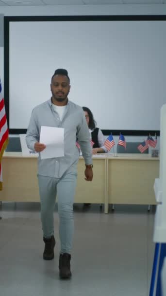 非洲裔美国人男子从投票站的女投票官手中接过纸面选票 走到投票站 美利坚合众国的全国选举日 公民义务和民主 — 图库视频影像