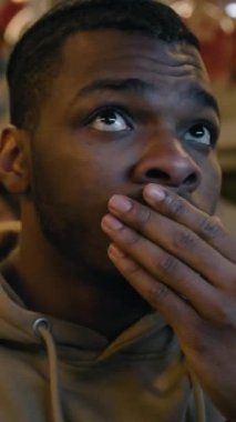 Arkadaşların dikey çekimi televizyonda spor barında canlı yayın yapıyor. Taraftarlar turnuvada oynayan favori takımı desteklemek için toplandılar. Futbol maçında seyirciler takımlarını destekliyor. Kapat..