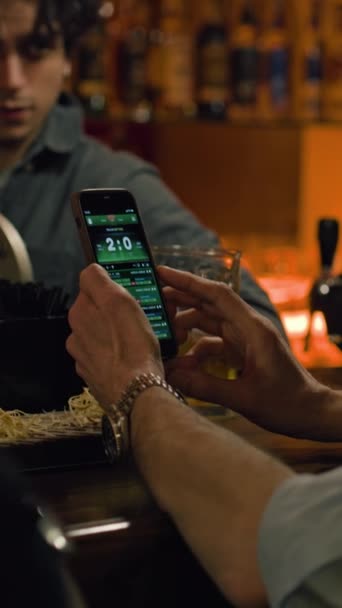 Erkek Arkadaşlarının Maç Skorlarını Bahisçi Reytinglerini Cep Telefonu Kullanarak Barmenle — Stok video