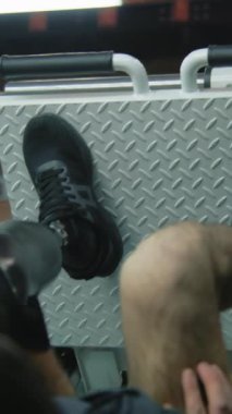 Modern fitness merkezinde bacak pres makinesinde protez bacaklı dikey şut atleti. Yapay bacaklı yetişkin bir sporcu profesyonel spor aletleri kullanarak güç eğitimi alıyor.