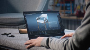 Yaratıcı adam, mobilya tasarımı ve dizüstü bilgisayarda çalışan 3D modelleme için profesyonel yazılım kullanır. Tasarımcı, şık ahşap sandalyenin dijital 3D modelini yaratıyor, marangozluk projesini hazırlıyor.