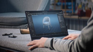 Yaratıcı adam, mobilya tasarımı ve dizüstü bilgisayarda çalışan 3D modelleme için profesyonel yazılım kullanır. Tasarımcı, şık ahşap sandalyenin dijital 3D modelini yaratıyor, marangozluk projesini hazırlıyor.