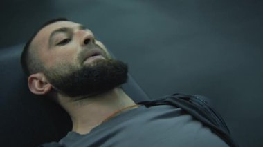 Spor salonunda ya da fitness merkezinde bacak presi makinesinde çalışırken derin nefes alan protez bacaklı bir atletin portresi. Yetişkin sporcu, profesyonel spor malzemelerini kullanarak spor yapıyor..