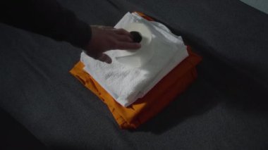 Mahkumun yüksek açılı portakal rengi hapishane üniforması ve banyo aksesuarlarını yatağın üzerine koyması. Suçlu suçlu, tutuklu hapiste suçtan hapis yatıyor. Gözaltı merkezi ya da ıslah evi.