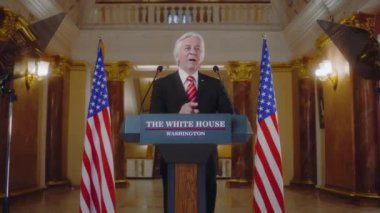 ABD 'nin olumlu başkanı Beyaz Saray' da ilham verici bir konuşma yapıyor. Üst düzey ABD hükümet temsilcisi basın ve televizyon konferansında konuştu. Arka planda Amerikan bayrakları.