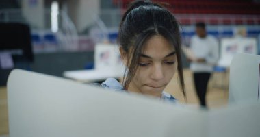 Afro-Amerikalı genç kadın seçmen oy verme kabinine geliyor. Amerikan vatandaşları oy kullanma merkezinde oy kullanıyor. ABD başkan adaylarının siyasi ırkları. Birleşik Devletler 'de Ulusal Seçim Günü. Kapat..