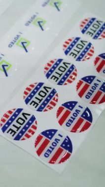 Masada Amerikan bayrağı logosu ve yazıtları olan vatansever çıkartmaların dikey çekimi. Amerika Birleşik Devletleri 'nde seçimler. Başkanlık yarışı ve seçim haberleri. Demokrasi ve