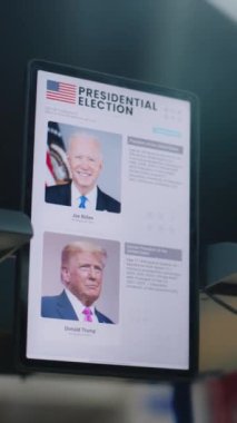 ZAPORIZHYA, UKRAINE - 15 Mart 2024: Fiziksel engelli kadın tablet bilgisayar kullanarak seçim yapıyor ve oy kullanıyor. ABD başkan adaylarının siyasi ırkları. Ulusal Seçimler