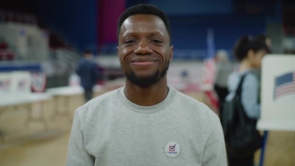 Muotokuva Afroamerikkalaisesta Miehestä Joka Hymyilee Katsoo Kameraa Äänestyspaikalla Onnellinen Yhdysvaltain — kuvapankkivideo