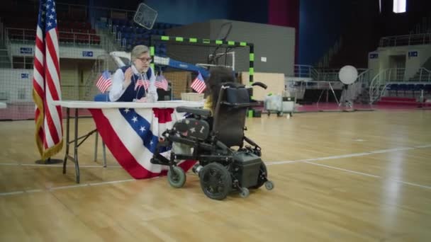 坐轮椅的脊柱肌肉萎缩的妇女在投票站与工作人员会诊 美国总统候选人的政治竞争 美国的全国选举日 Dolly Shot — 图库视频影像
