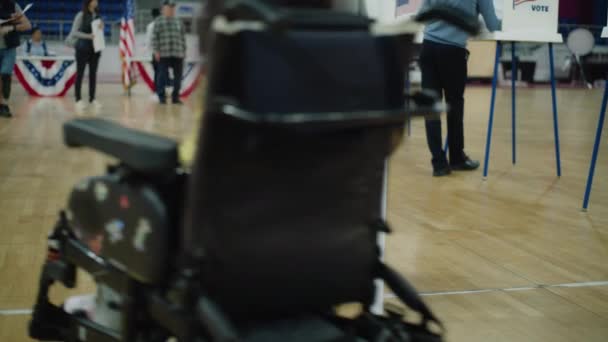 在这里投票在地板上签名 坐轮椅的脊椎肌肉萎缩的妇女来到投票站投票 美国总统候选人的政治竞争 全国选举日 Dolly Shot — 图库视频影像