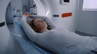 Kadın hasta MRI ya da CT taramasından geçiyor. Yatakta makinenin içinde hareket ediyor. Beyin ve kadın vücudunu taramanın görsel etkileri. Gelişmiş tıp laboratuarında ileri teknoloji gerçeklik ekipmanları.
