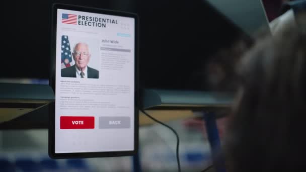 美国女性公民在投票站的投票亭中做出选择 身体残疾的妇女通过平板电脑进行投票和阅读信息 美国的总统选举 — 图库视频影像