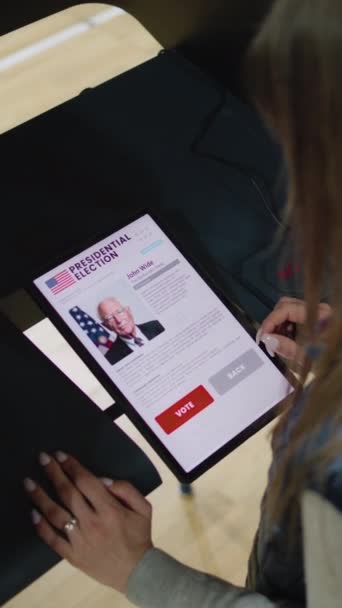 여성은 태블릿 컴퓨터를 사용하여 부스에서 대통령 후보에 선택과 투표를합니다 선거일 — 비디오