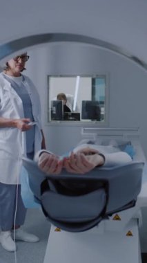 Tomografide, PET 'te ya da MRI tarama yatağında yatan hastanın dikey görüntüsü. Gelişmiş ekipman, modern teknolojilerle tıbbi tesiste vücut ve beyin taramaları yapıyor. Ayrıntılı muayene ve teşhis.