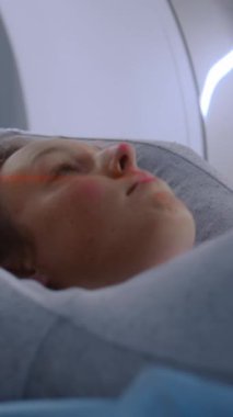 Tomografide, PET 'te ya da MRI yatağında yatan hastanın dikey görüntüsü. Son teknoloji ürünü ekipmanlar, ileri teknolojilerle tıbbi tesislerdeki hasta vücudunu ve beynini tarıyor. Ayrıntılı sağlık hizmetleri