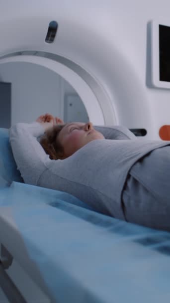 妇女躺在Ct或Pet或Mri扫描床上 在机器内移动的垂直照片 用高科技现代设备扫描病人的身体和大脑 具有先进技术的医疗设施 — 图库视频影像