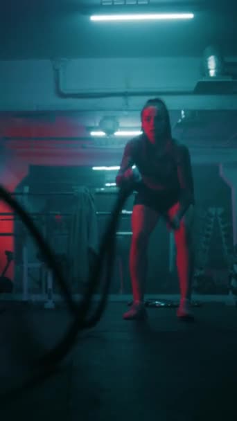 女子运动员在黑暗拳击馆进行带Led灯的战斗绳索练习 女拳击手在冠军赛前做有氧运动或耐力锻炼 垂直射击 — 图库视频影像