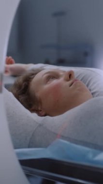 Tomografide, PET 'te ya da MRI makinesinde yatan kadın hastaların dikey görüntüsü. Gelişmiş aletler, tıbbi tesiste detaylı muayene için vücudu ve beyni tarıyor. Yüksek teknoloji, modern tıp laboratuarı. Sağlık Hizmetleri.