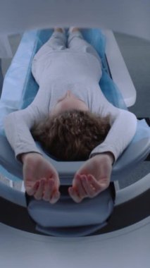 Bilgisayarlı tomografide, PET 'te ya da MRI yatağında makinede gezinen kadın hastaların dikey görüntüsü. Yüksek teknolojili ekipman, doğru teşhis için bir tıbbi tesiste vücut ve beyin taraması yapar. Son teknoloji sağlık ekipmanları..