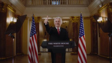 Birleşik Devletler 'in yeni başkanı Beyaz Saray' daki basın kampanyası sırasında gülümsüyor ve jestler yapıyor. Olumlu başbakan medya ve televizyon kameralarına poz veriyor. Arka planda Amerikan bayrakları.