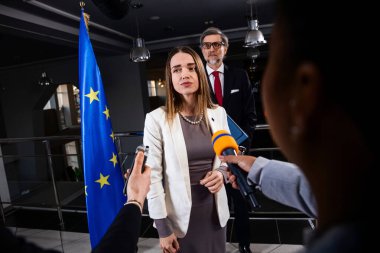 Basın kampanyası sırasında AB konsolosluğunun siyasi konuşması. Avrupa Parlamentosu binasında gazetecilerin sorularını yanıtlayan, medya ve televizyon haberleri için röportaj veren kendinden emin Avrupalı kadın siyasetçi.