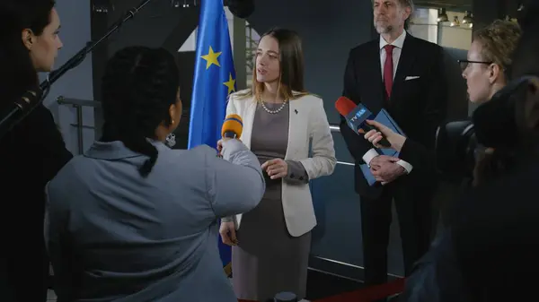 ポジティブなヨーロッパの女性政治家はジャーナリストの質問に答え 欧州議会の建物でメディアやテレビのインタビューを行います 記者会見で欧州連合代表 — ストック写真
