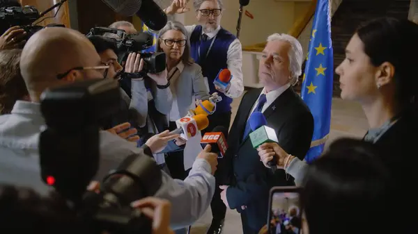 欧盟代表回答媒体提问 并接受电视新闻采访 高级领事被一群记者包围着 新闻发布会上的政治演讲 国家状况 图库图片