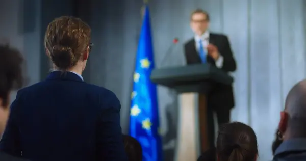 stock image Female representative of media asks question to European politician performing at press conference. Confident EU consul makes an announcement, delivers campaign speech, gives interview. Election day.